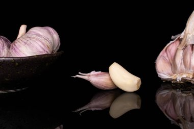 Beyaz aromalı sarımsak siyah camda izole edilmiş.