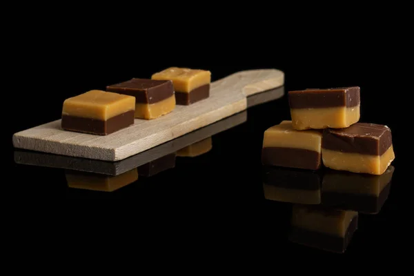 Karamel chocolade snoep geïsoleerd op zwart glas — Stockfoto