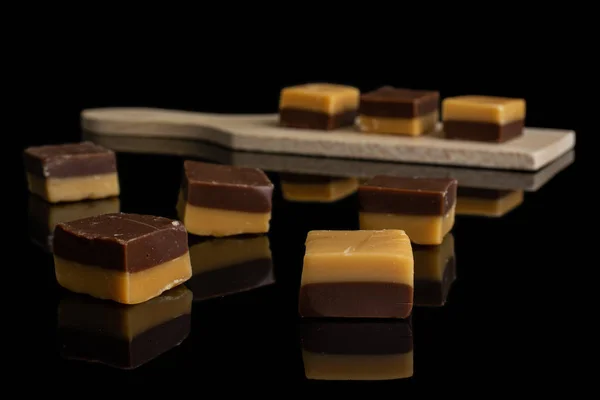 Karamel chocolade snoep geïsoleerd op zwart glas — Stockfoto