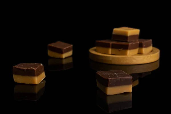 검은 유리 위에 올려 놓은 카라멜 초콜릿 사탕 — 스톡 사진
