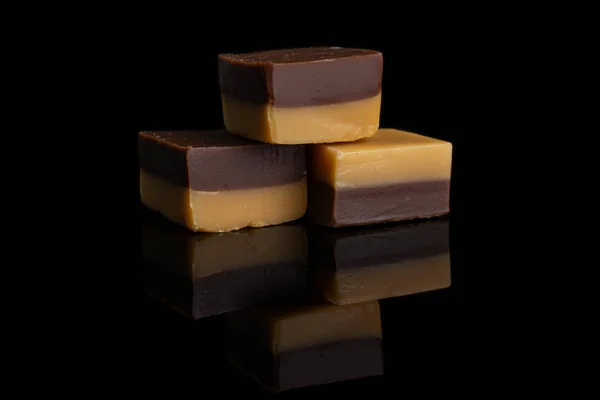 Bomboane de ciocolată caramel izolate pe sticlă neagră — Fotografie, imagine de stoc