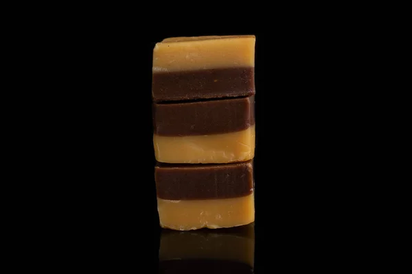 검은 유리 위에 올려 놓은 카라멜 초콜릿 사탕 — 스톡 사진