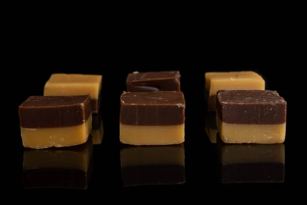 Karamel chocolade snoep geïsoleerd op zwart glas — Stockfoto