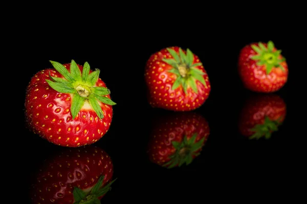 Frische rote Erdbeere isoliert auf schwarzem Glas — Stockfoto