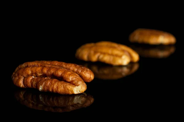 Droge bruine pecannoten geïsoleerd op zwart glas — Stockfoto