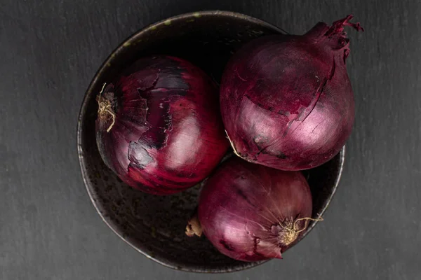 Cebolla roja fresca sobre piedra gris — Foto de Stock