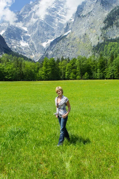 Eine Junge Frau Auf Der Wiese Mit Bergen Hintergrund Zeigt — Stockfoto