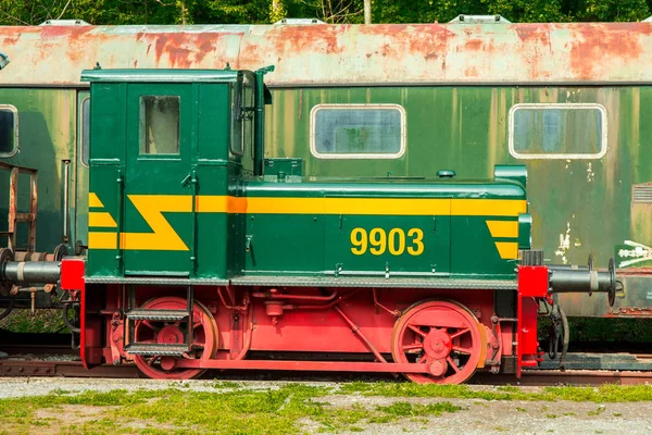 Varios vagones oxidados y tren en las vías — Foto de Stock