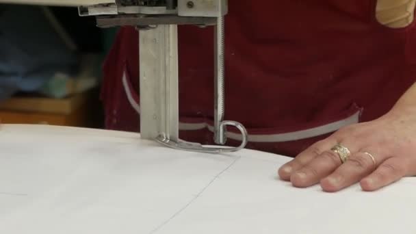 Mujer joven en fábrica textil de tela trabaja con la máquina de corte. Creando máscaras médicas. El trabajo de una costurera en cuarentena. pandemia de Coronavirus. De cerca. . — Vídeos de Stock