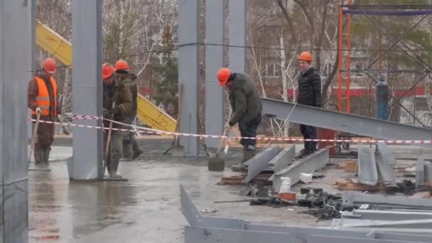 Beton gieten op een bouwplaats. Groep van bouwers werken samen aan het gieten van cement tijdens een upgrade van openbare projecten om residentiële straat bestrating te repareren, de bouw van huizen. Werkelijk — Stockvideo