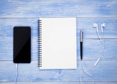 Masaya yerleştirilen telefon, kalem ve kulaklıklar ile Mavi Masa üst görünümü.