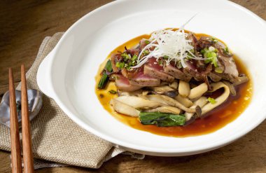 Beyaz bir çanak Tuna biftek ahşap bir masaya yerleştirilir, Japon gıda