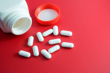 Kırmızı arka planda hap yığını