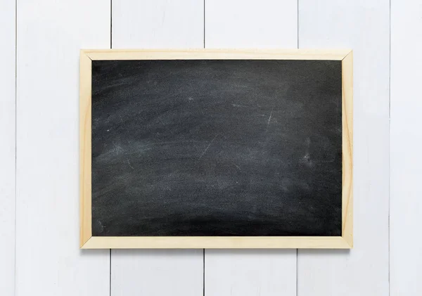 Blackboard / chalkboard texture. Empty blank black chalkboard with chalk traces on white wood table — Stock Photo, Image