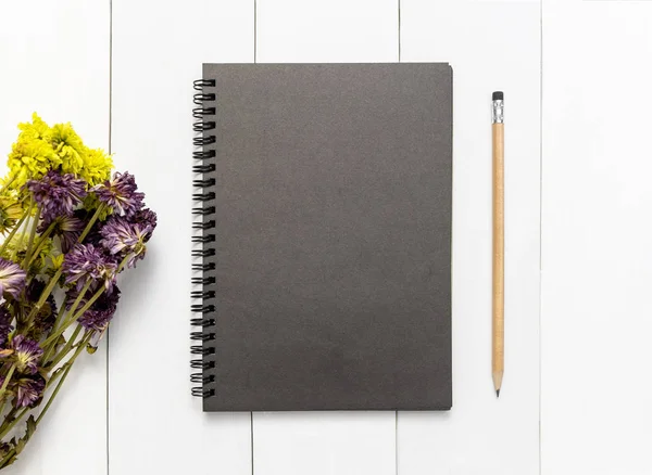 Notebook and pencil on wood white table background for mockup, View from above with copy space