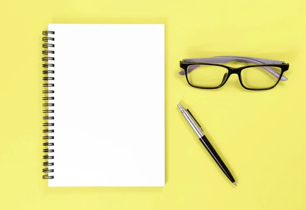 Psací notebook, pero a brýle na barevném pozadí s prostorem pro kopírování. pohled shora — Stock fotografie