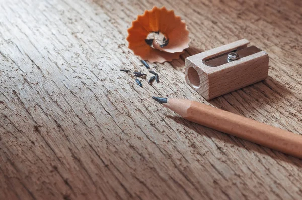 Ołówek drewniany z ostrzeniem wiórów na starym drewnianym tle tekstury — Zdjęcie stockowe