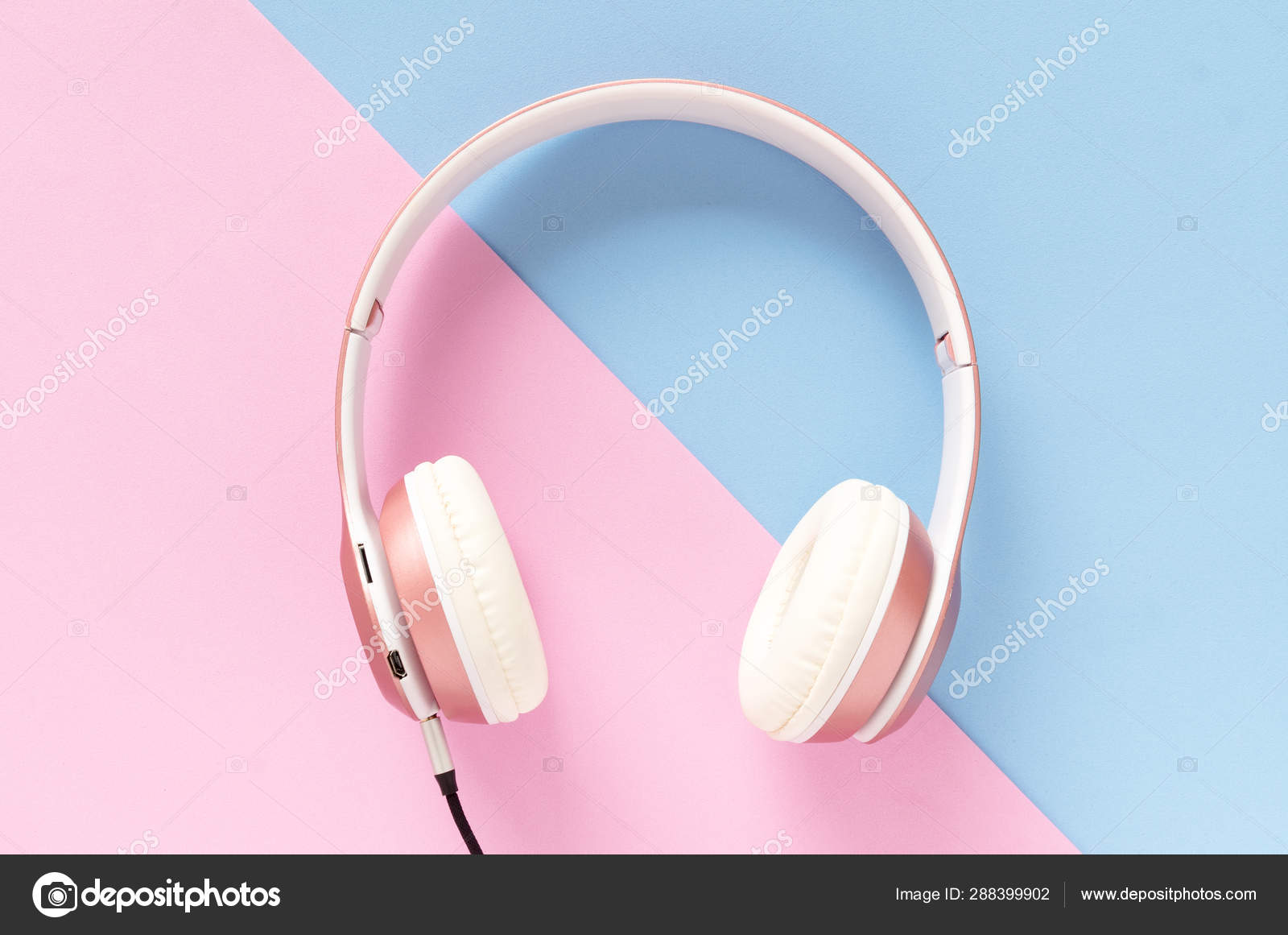 Pink headphone and black cable on pastel color blue and pink background.  Music concept. Stock Photo by ©noomubon 288399902