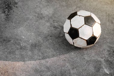 Eski futbol. Siyah ve beyaz futbol topu beton zemin üzerine yerleştirilir.