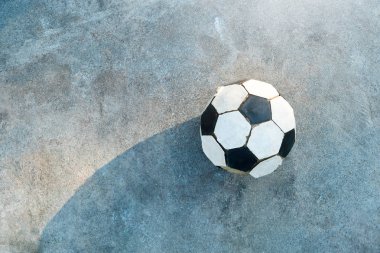 Eski futbol. Siyah ve beyaz futbol topu beton zemin üzerine yerleştirilir.