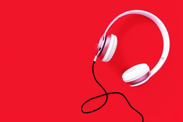 Pink headphone and black cable on pastel color red background. Music concept. Blank copy space — Stock Photo, Image