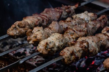  Lezzetli bir barbekü, şiş üzerinde bir ateşte, arkadaşlarla piknikte hazırlanır.