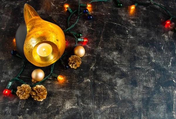 Weihnachten fabelhafte Komposition mit einem ungewöhnlichen Kerzenständer, Kerze, goldenen Zapfen und Neujahrslichtern - geheimnisvoll — Stockfoto