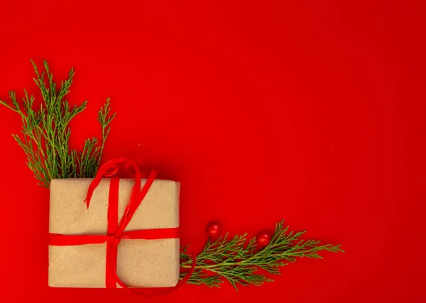 Noel ve yeni yıl kartı, geçmiş - ladin, kırmızı arka planda hediyeler, simetri. Düz konum, boşluk kopyala, üst görünüm