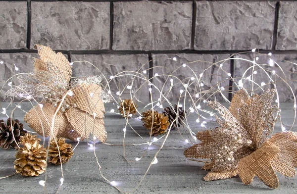 Schöne Weihnachtsdekoration in silbrigen Goldtönen, goldene Tannenzapfen, Weihnachtsbeleuchtung und Blume auf Betongrund — Stockfoto