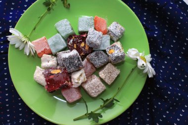 Türk lokumu ve yeşil zemin üzerine taze papatya tatlılar