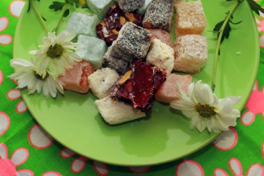 Türk lokumu ve yeşil zemin üzerine taze papatya