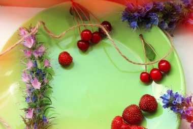 Yaz sezonu kavramı. Kiraz ve çilek yeşil plaka üzerinde. Kopya alanı