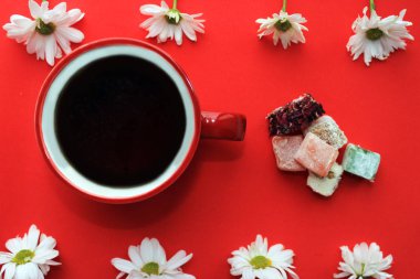 Çay ve tatlılar, Türk lokumu ve kırmızı zemin üzerine taze papatya