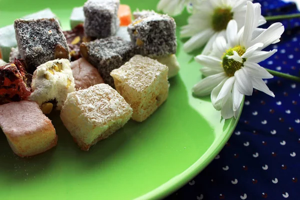 Sonbahar ev coziness. Yeşil plaka ve papatya çiçekler üzerinde Türk tatlılar lokum.