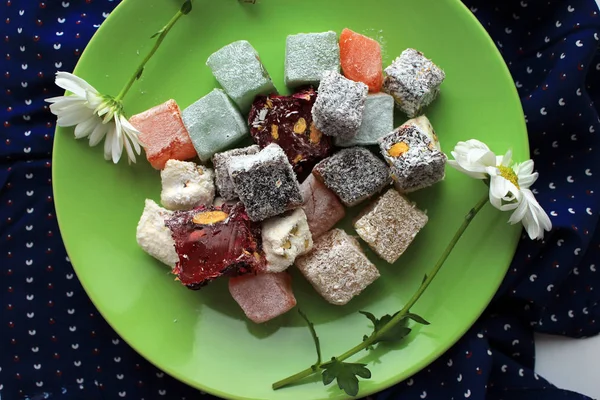 Sonbahar ev coziness. Yeşil plaka ve papatya çiçekler üzerinde Türk tatlılar lokum.