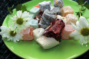 Ev coziness. Türk tatlı ve taze papatya çiçekleri yeşil plaka üzerinde düz yatıyordu. Yakın çekim. 