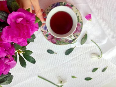 Ev coziness. Sabah kahvaltısı: çay; pembe açelya çiçek. Sakin ol. Düz yatıyordu