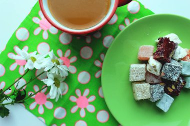 Sonbahar coziness. Kırmızı bir fincan, Türk lokumu ve yeşil zemin üzerine taze papatya sıcak çay ile Servis Kahvaltı. Üstten görünüm