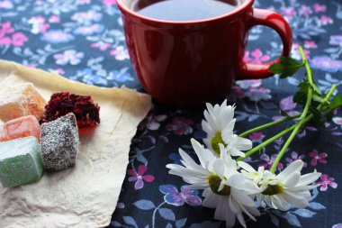 Sonbahar coziness. Kırmızı bir fincan, Türk lokumu ve mavi zemin üzerine taze papatya sıcak çay ile Servis Kahvaltı