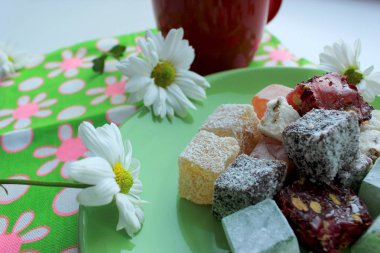 Sonbahar coziness. Kırmızı bir fincan, Türk lokumu ve yeşil zemin üzerine taze papatya sıcak çay ile Servis Kahvaltı. 