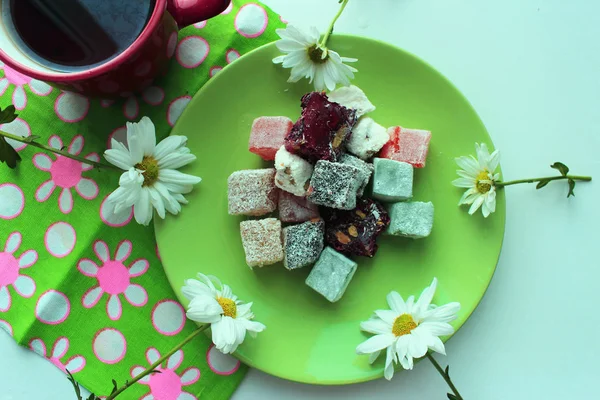 Sonbahar coziness. Kırmızı bir fincan, Türk lokumu ve yeşil zemin üzerine taze papatya sıcak çay ile Servis Kahvaltı. Üstten görünüm