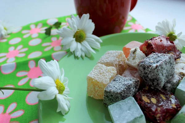 Sonbahar coziness. Kırmızı bir fincan, Türk lokumu ve yeşil zemin üzerine taze papatya sıcak çay ile Servis Kahvaltı. 