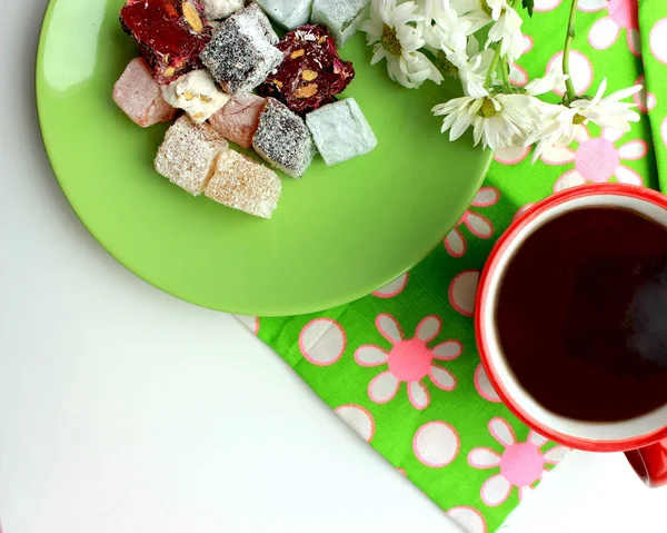 Sonbahar coziness. Kırmızı bir fincan, Türk lokumu ve yeşil zemin üzerine taze papatya sıcak çay ile Servis Kahvaltı. Üstten görünüm