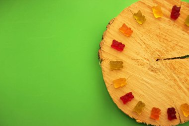 Sakızlı ayılar farklı renklerde. Kavram bebekler. Uzay kopyalayın. Gökkuşağı halfcircle yeşil arka plan üzerinde renkli tatlı sakızlı ayılar.