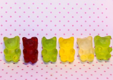 Kırmızı, yeşil ve sarı renkler sevimli pembe nokta arka plan üzerinde oyuncak ayılar jöle. Yakın çekim 