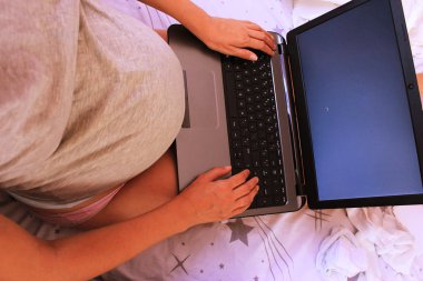 Hamile kadınlar inşaat ile dizüstü bilgisayar, göbek kadar kapatın