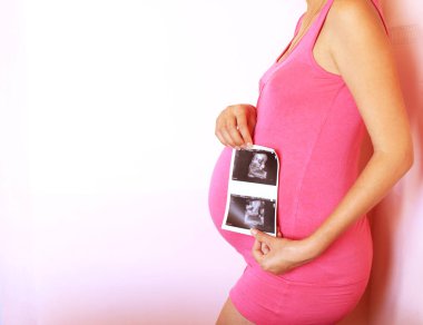 Hamile kadın ultrason görüntüsü sonraki göbek için tutar. Hamilelik, sağlık, kadın hastalıkları, tıp kavramı. Yakın çekim, kopya alanı.