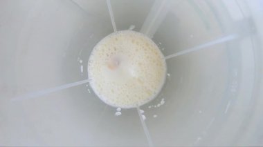 Mikserde dönen sütlü muzlu smoothie. Üst görüş ve yavaş çekim. GOPRO.