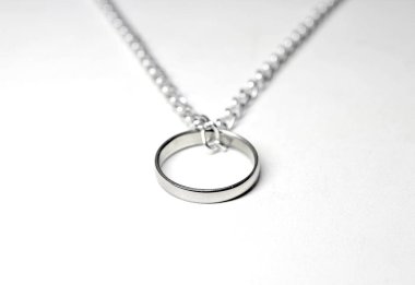 Zincire asılı gümüş yüzük. Beyaz arka plan üzerinde izole