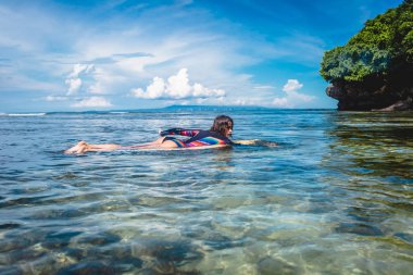 Okyanusu Nusa dua Beach, Bali, Endonezya sörf gemide genç sporcumuz wetsuit yan görünüm